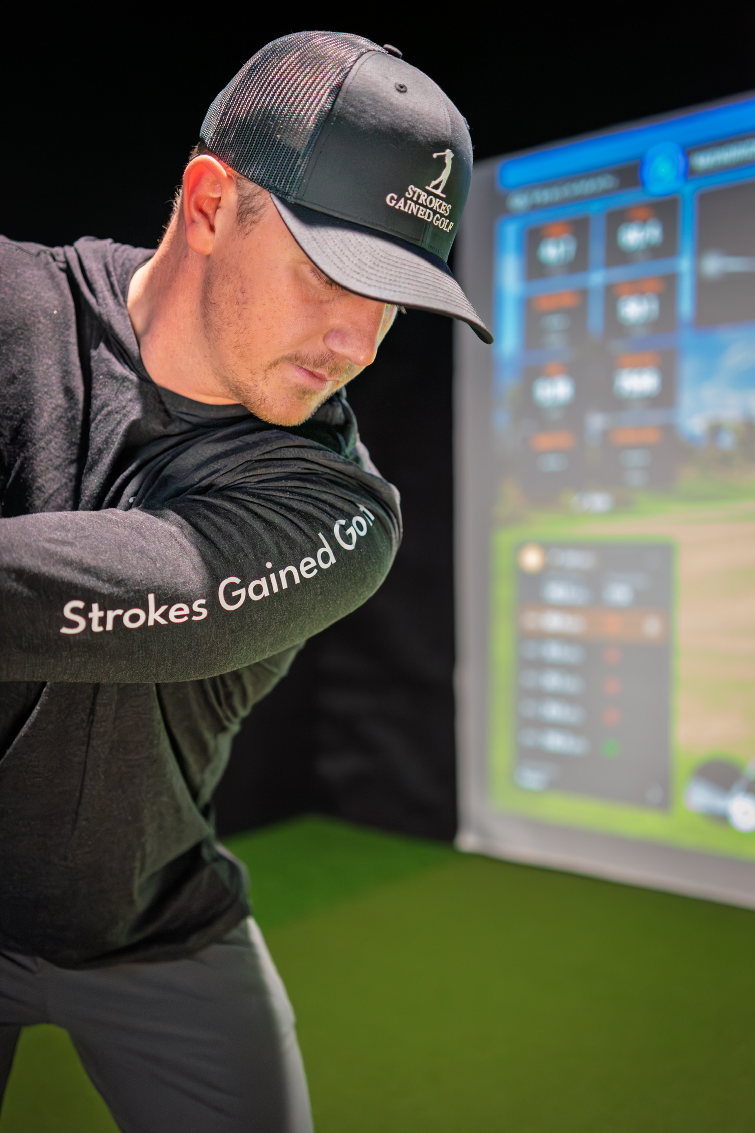 Golfer Using Simulator at Strokes Gained Golf